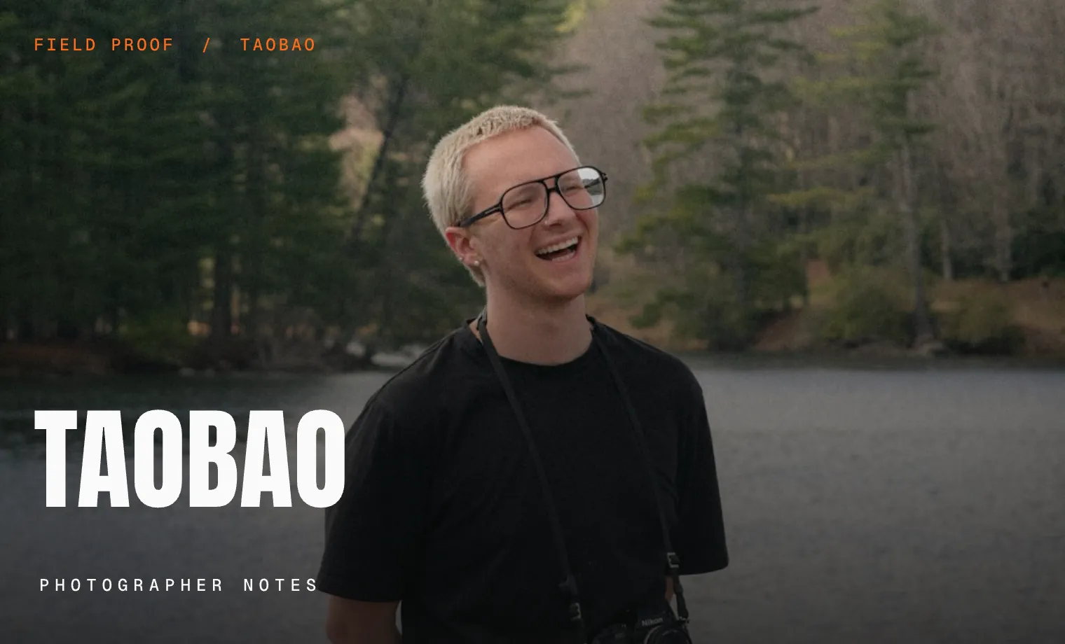 Working photographer laughing beside a forest lake