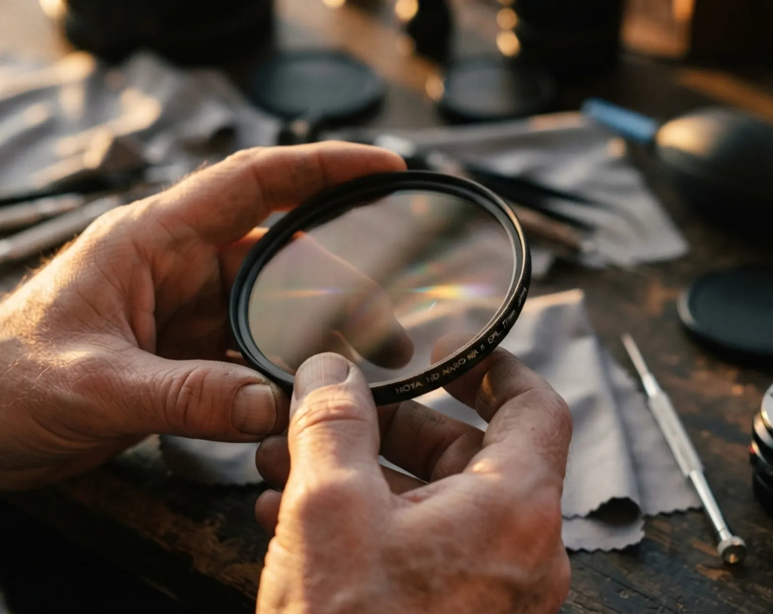 Hands inspecting an XT filter over a workshop bench