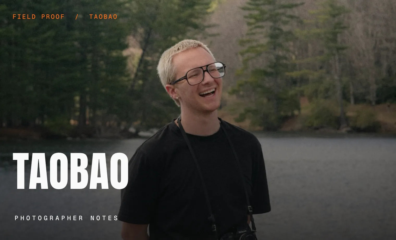 Working photographer laughing beside a forest lake